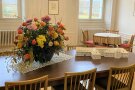 Blumendekoration auf einem Tisch neben einem Modell der Fachakademie Triesdorf