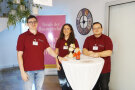 Eine Studentin und zwei Studenten begrüßen Besucherinnen und Besucher der Fachakademie